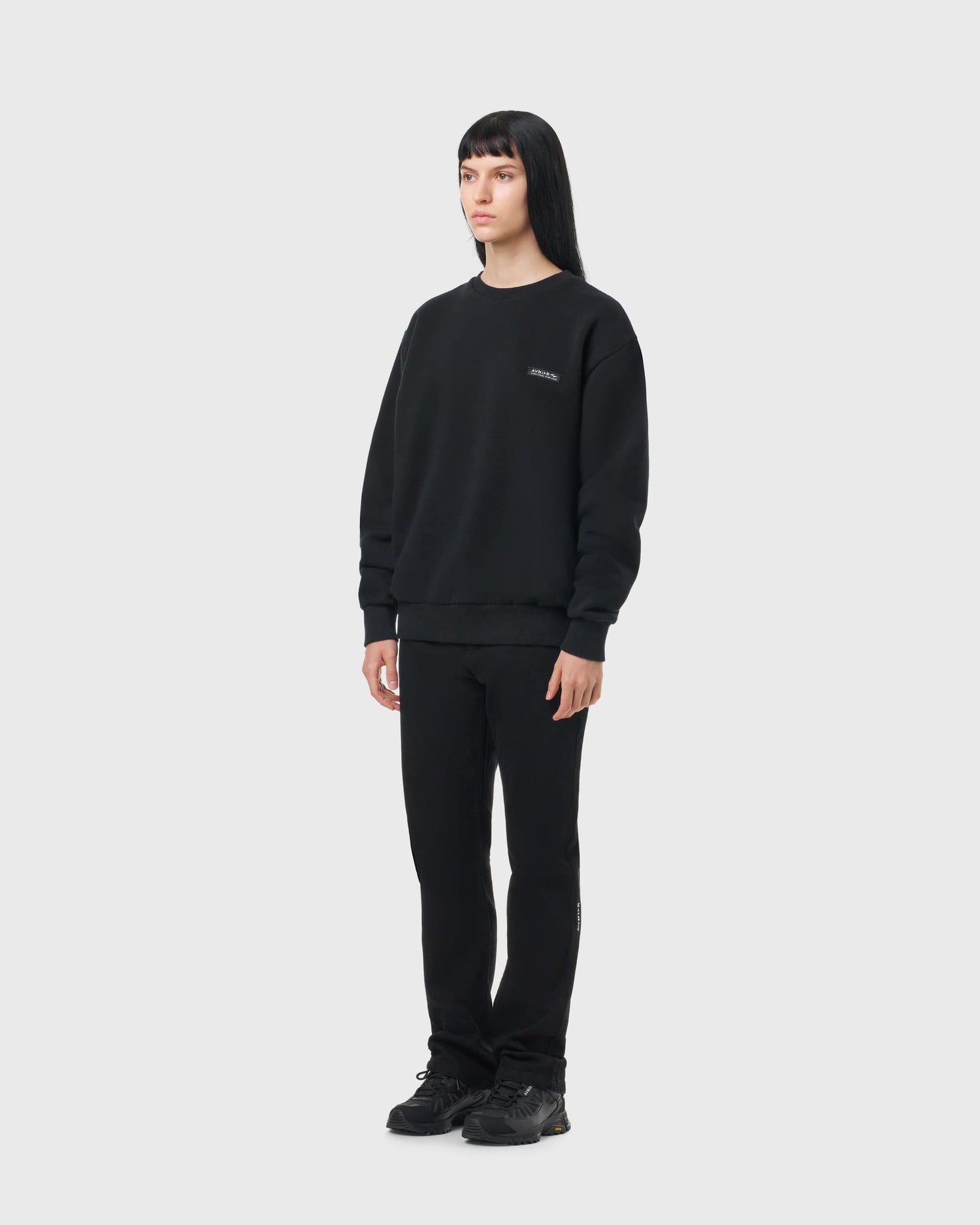 Sweat noir Avnier Encore V4 porté par une femme, coupe droite et look urbain décontracté.