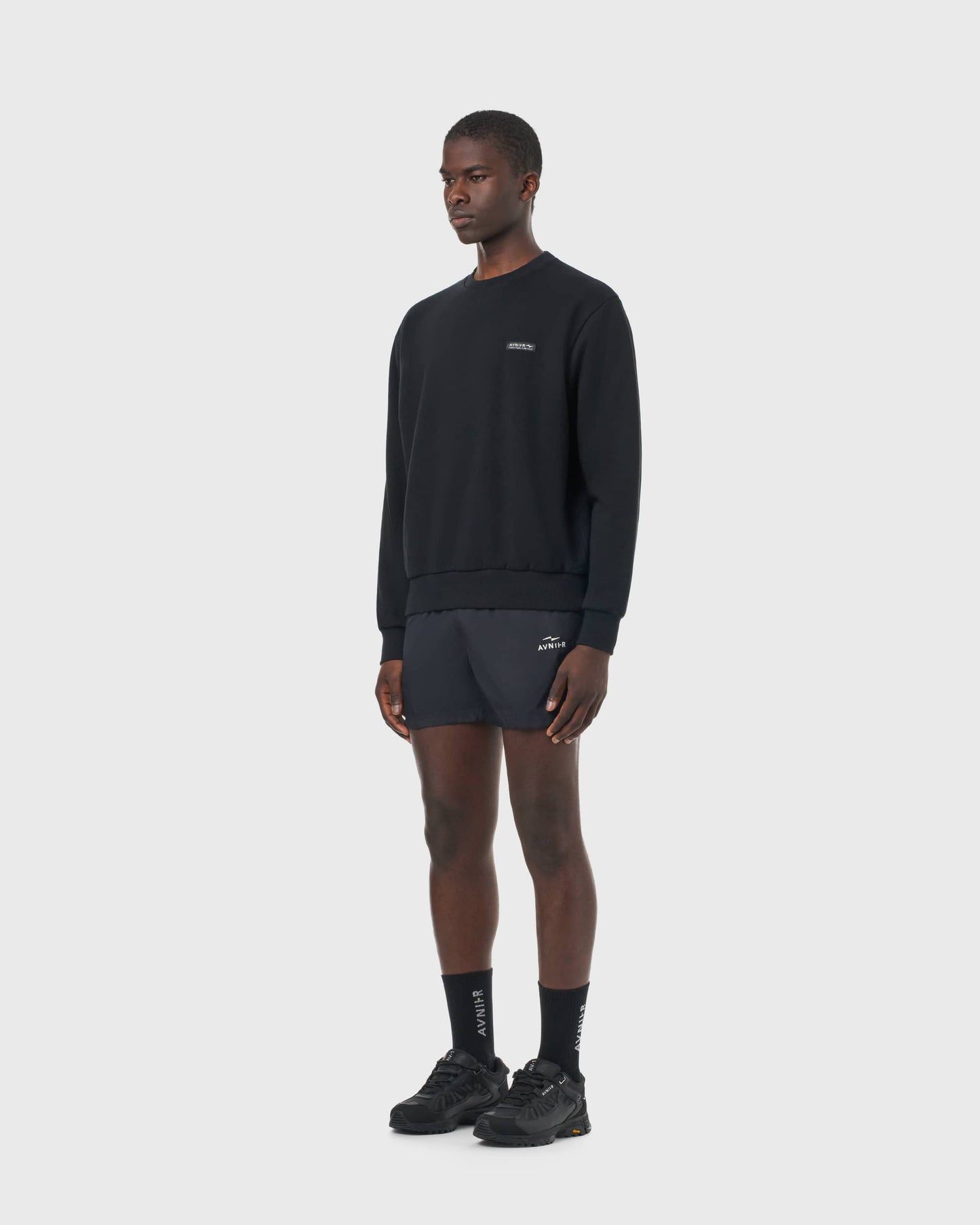 Sweat noir Avnier Encore V4 porté par un homme, vue de profil, look moderne et sobre.