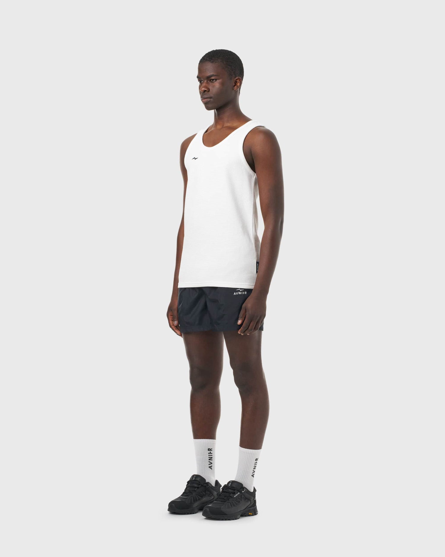 Débardeur blanc Avnier Aperture porté par un homme, vue de profil, look urbain et sobre.