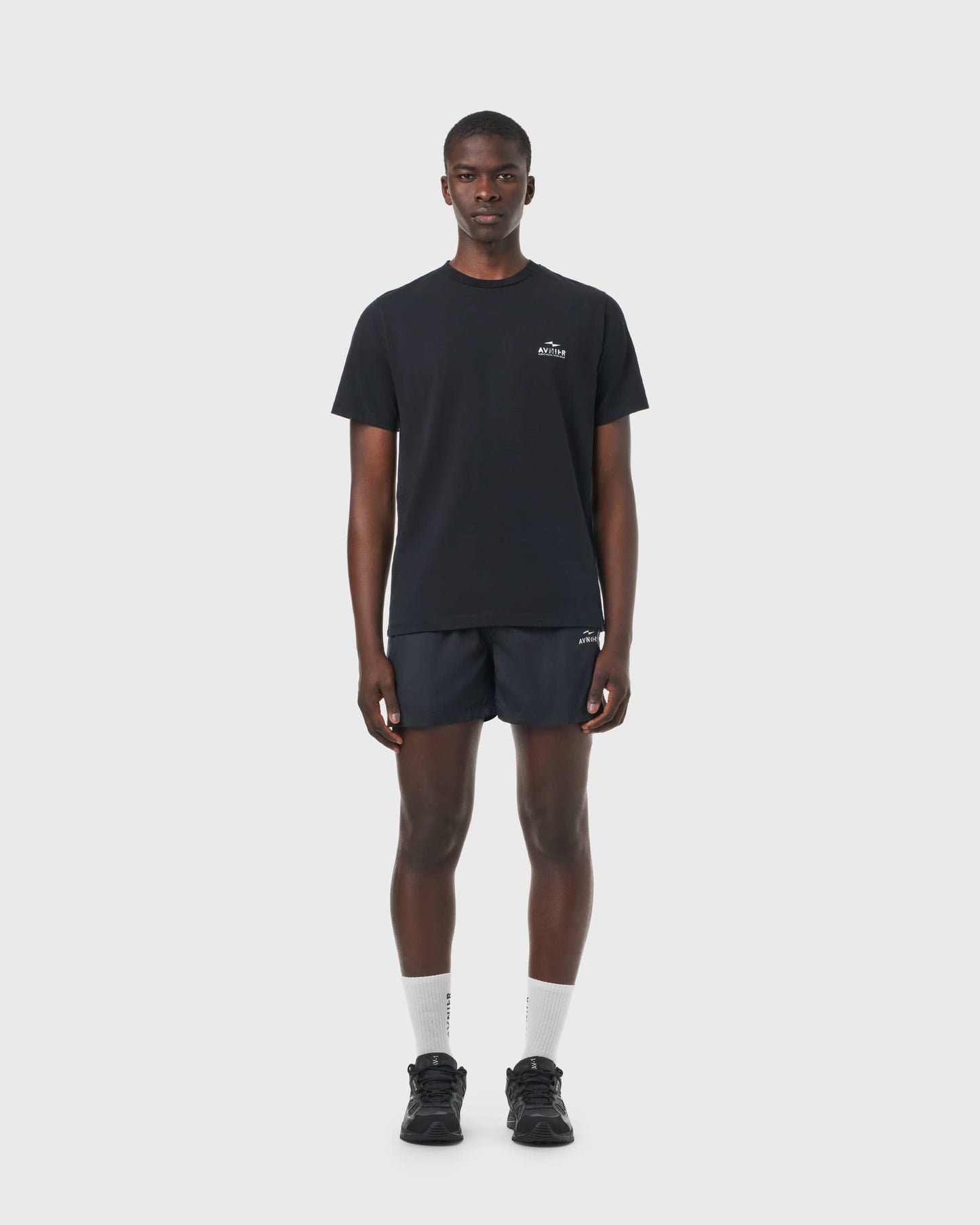 T-shirt noir Avnier Source Black Chrome Vertical porté par un homme, coupe droite et style minimaliste.