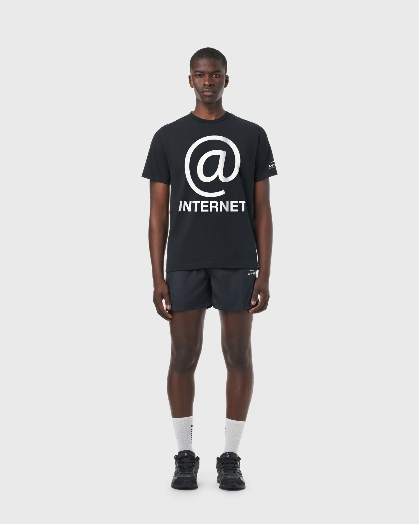 T-shirt Source Internet AVNIER noir porté de face, coupe droite en coton avec print arobase et texte « internet ».