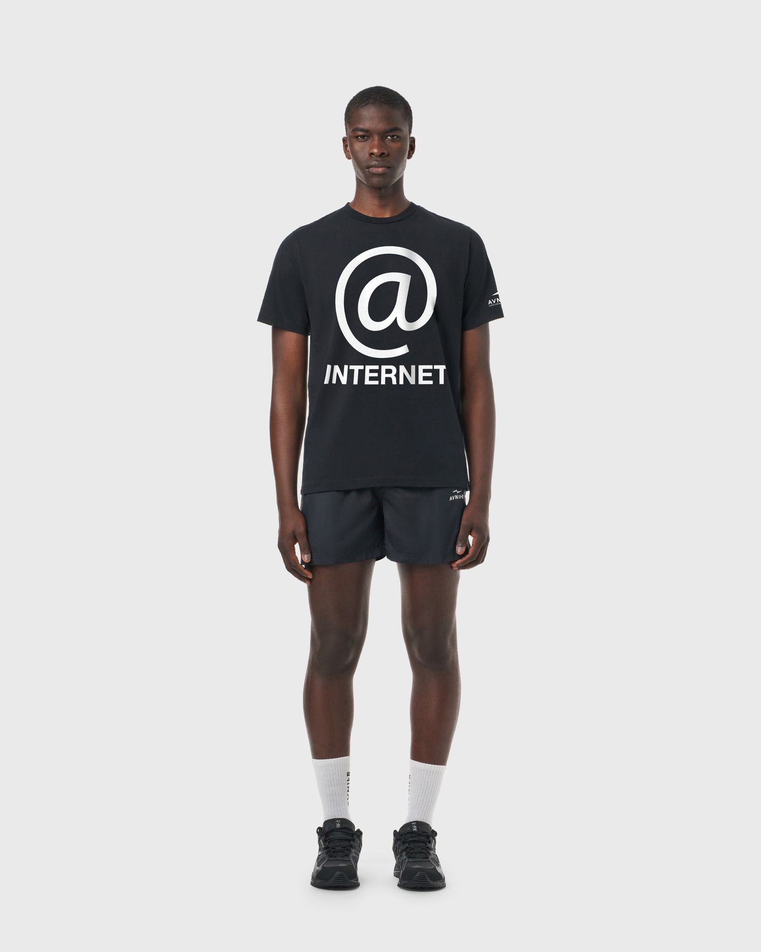T-shirt Source Internet AVNIER noir porté de face, coupe droite en coton avec print arobase et texte « internet ».