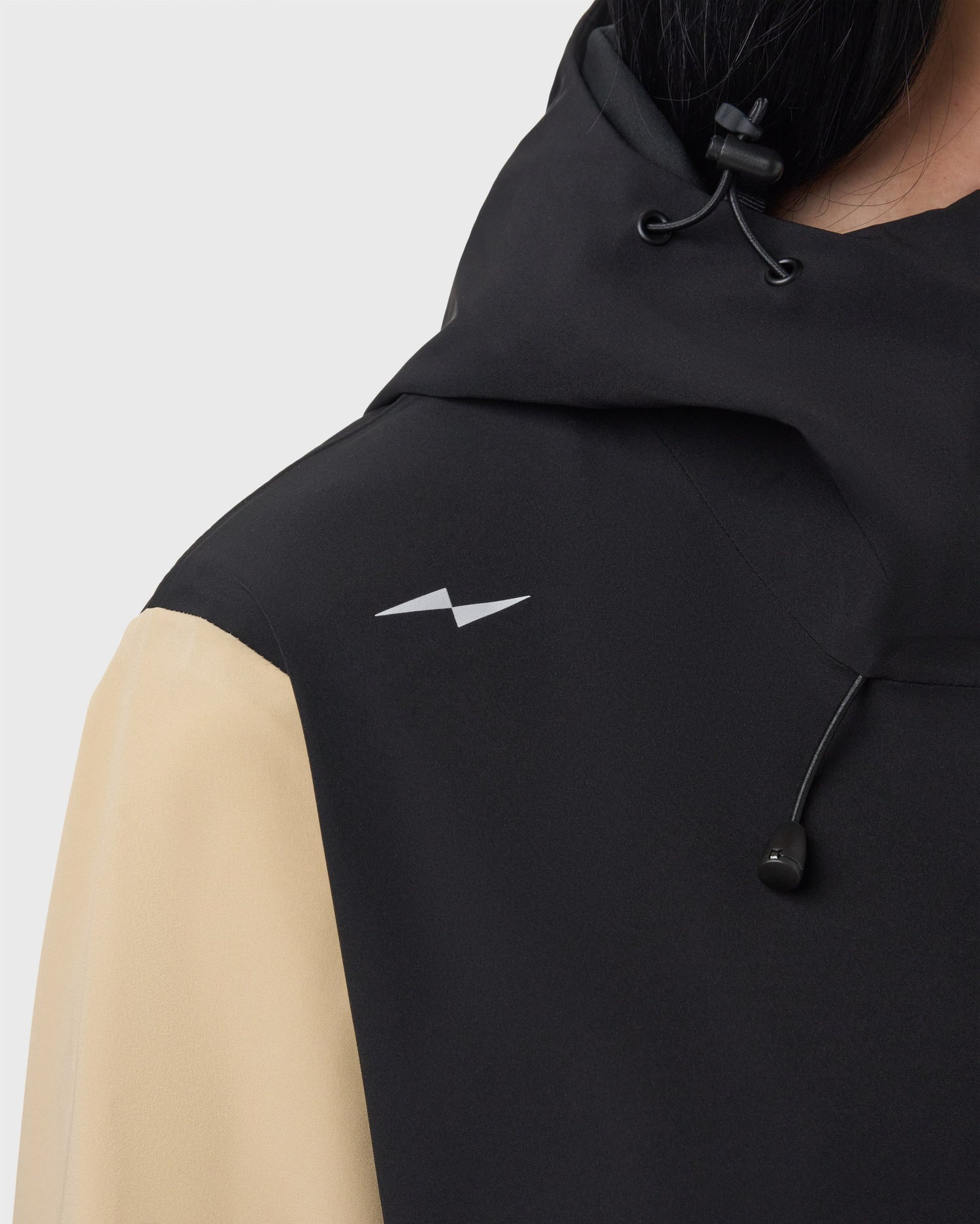 Détail du logo Avnier sur l’épaule de la veste Interlude beige, signature discrète de la marque. - beige