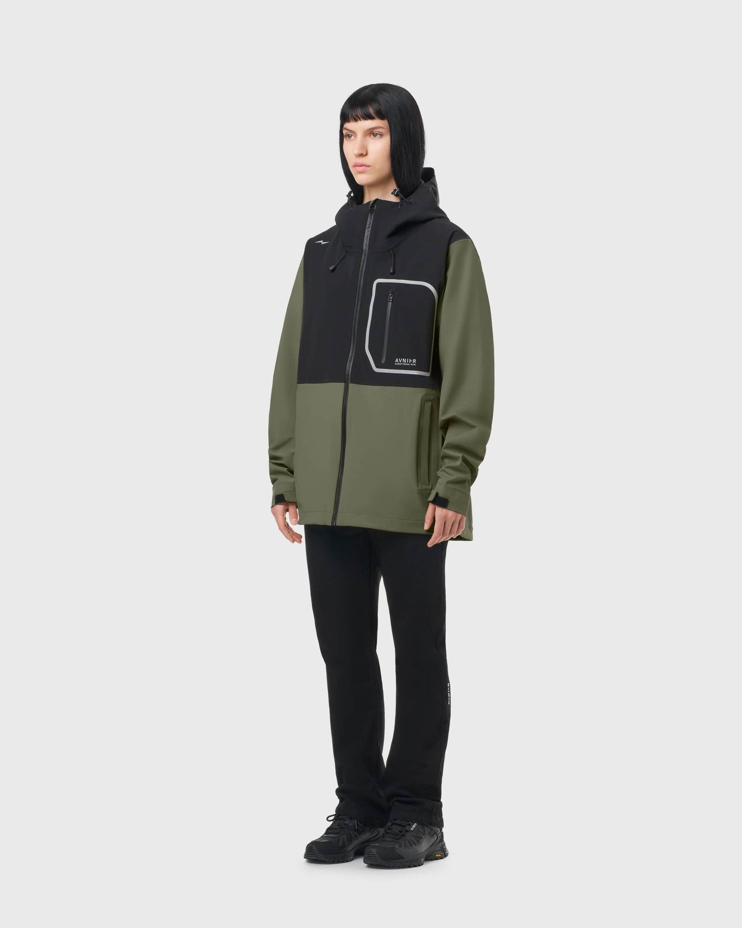 Veste imperméable AVNIER Interlude kaki et noire portée par une femme de profil, coupe technique 3 couches. - kaki